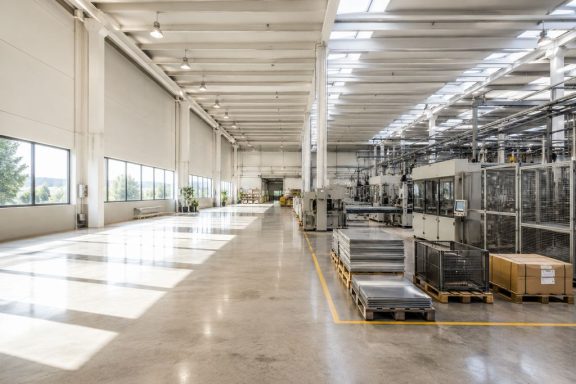 Interior de fàbrica industrial Fotografia professional d’interior de fàbrica amb zona de producció, maquinària industrial, espai ampli i il·luminació natural.